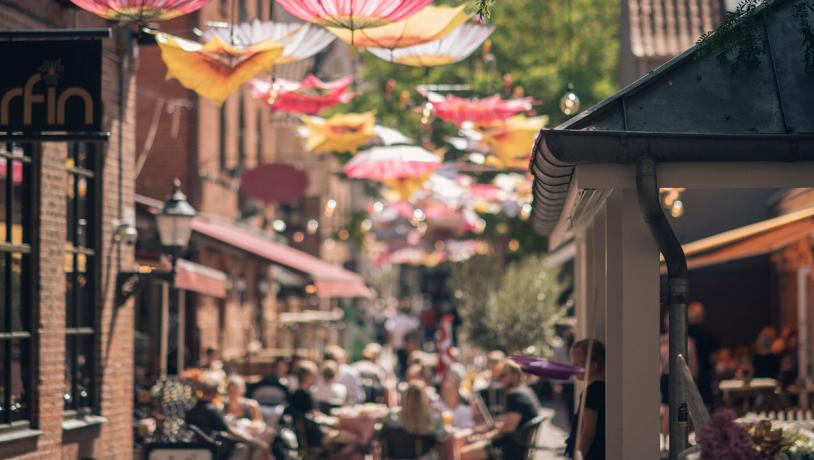 Passage med paraplyer og caféliv