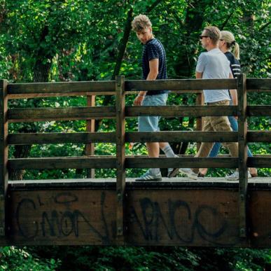 Fodgængere på bro med grafitti