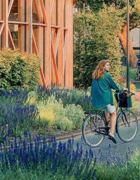 Pige på cykel ved hca hus