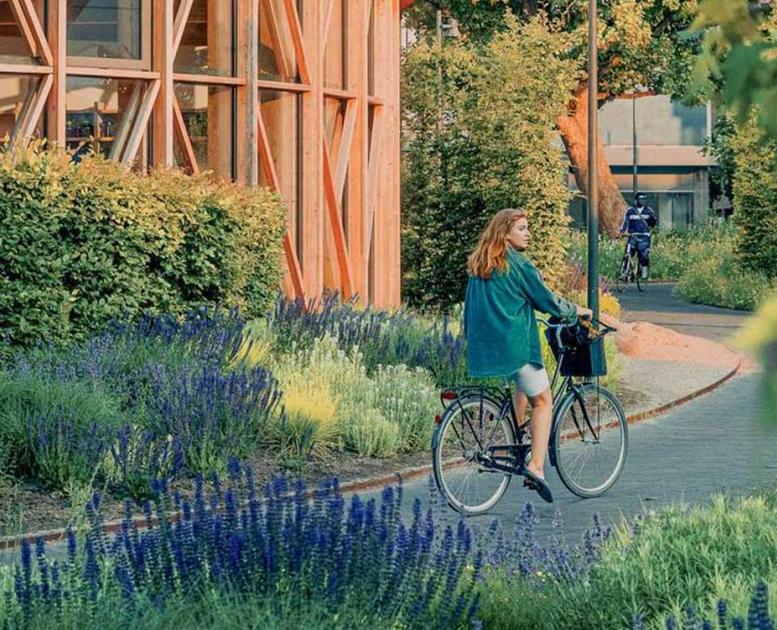 Pige på cykel ved hca hus